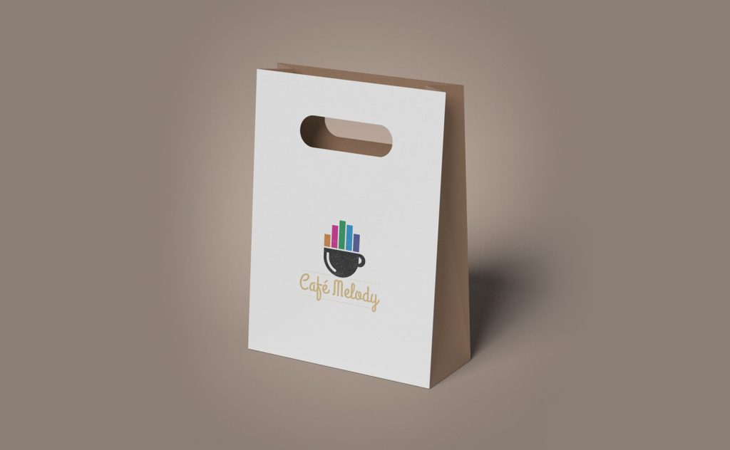 White paper bag with Café Melody logo featuring a coffee cup and colorful bars resembling piano keys