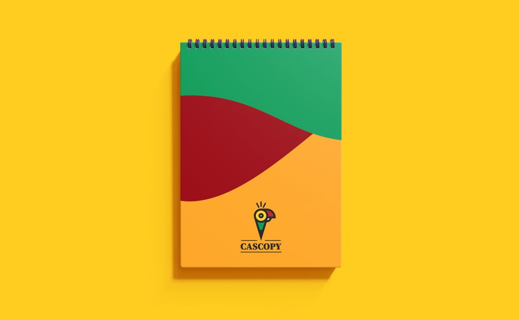 CAScopy logo on a colorful notebook cover with green, red, and orange design on a yellow background.