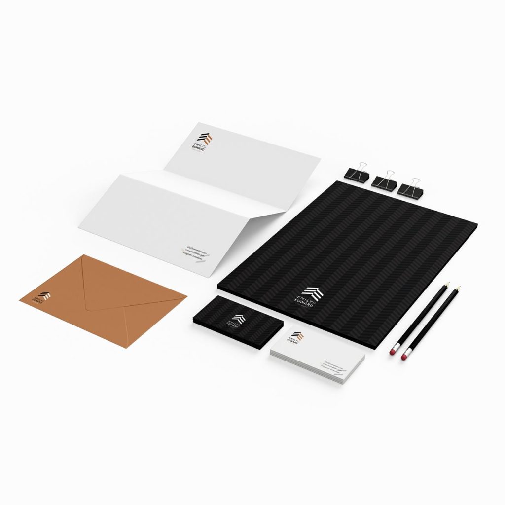 Emily & Edward real estate logo on a stationery set including business cards, envelopes, letterhead, and writing tools in black, white, and golden-beige.